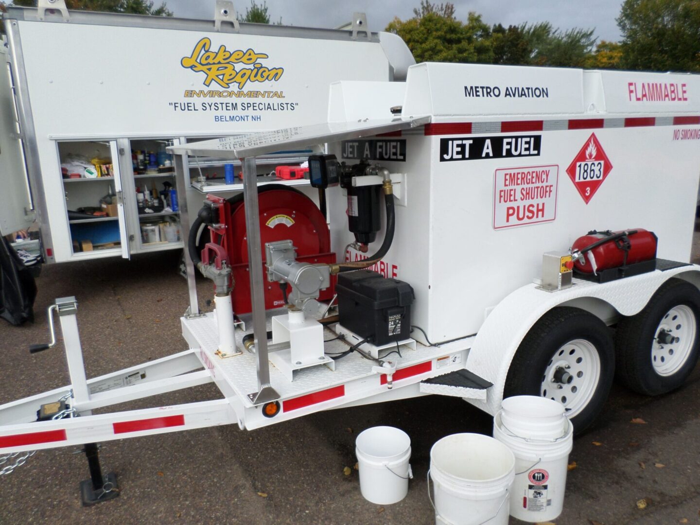 A white trailer with two buckets on the side of it.